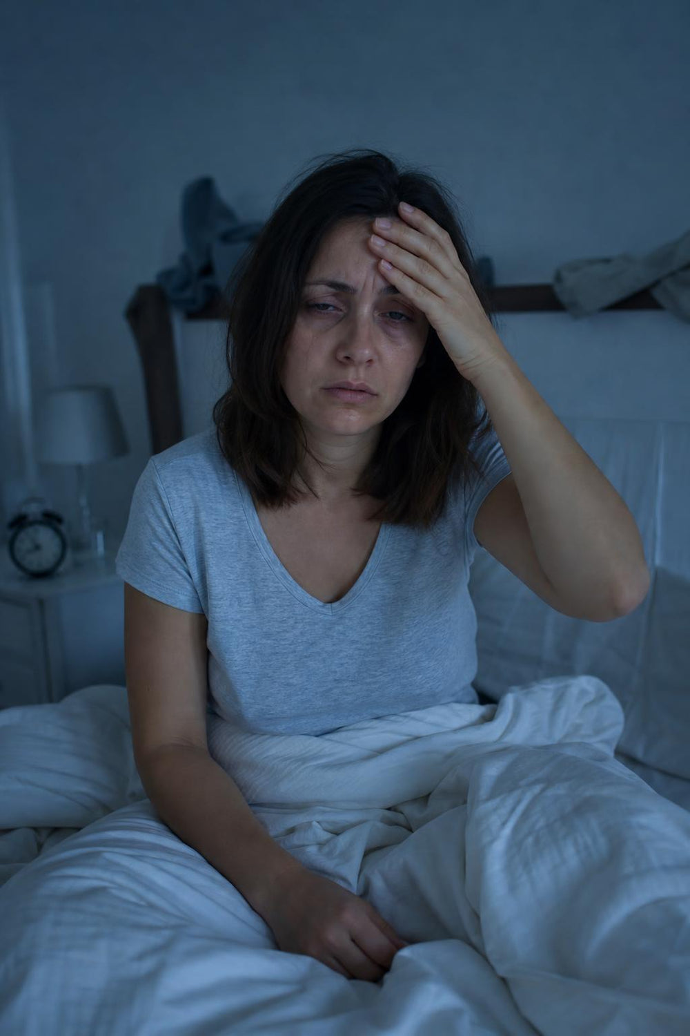 Mujer despertándose cansada en su cama con luz fría
